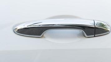 Beautiful chrome car door handle. On the white car floor. photo