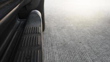 Car side oriented steel railing for stepping up trucks. Blurred background of cement floor. photo