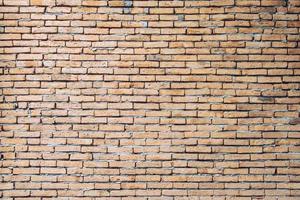 Vintage old brick wall background. A brick is a type of block used to build walls, pavements and other elements in masonry construction. photo