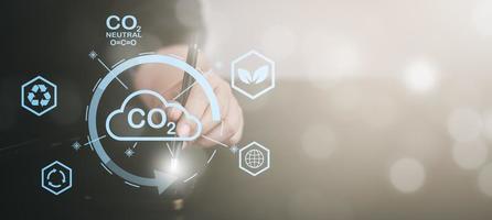 mano sostener teléfono inteligente y global red conexión con virtual moderno reducir co2 emisión concepto con iconos, global calentamiento emisiones carbón huella clima cambio a límite global calentamiento, energía foto