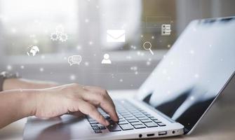 businessman hand type on the laptop of company profit with colleagues partner explain with virtual dashboard statistic chart stock infographic, graphs, cryptocurrency, and new trading platforms photo