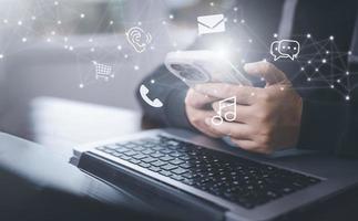 Communication and Contact us or Customer support hotline people connect. Hand using a laptop and touching on virtual screen contact icons, email and address, live chat with internet wifi. photo