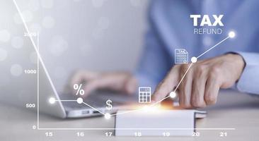 Concept of tax payment optimisation business finance,Man using calculator and taxes icon on technology screen,income tax and property, background for business, individuals and corporations such as VAT photo