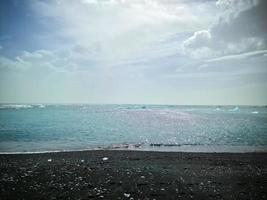 playa de diamantes en islandia con icebergs azules derritiéndose sobre arena negra y hielo brillando con la luz del sol. foto