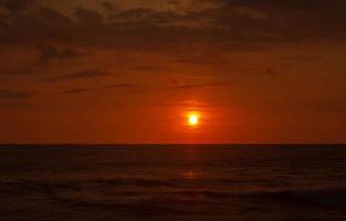 rojo puesta de sol terminado océano. hermosa noche cielo foto