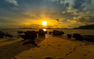 dramático Oceano puesta de sol con rocas foto