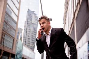 chico en un traje hablando en el teléfono sorprendido foto