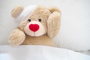 The teddy bear has gauze on the head. Child Injury Concept photo