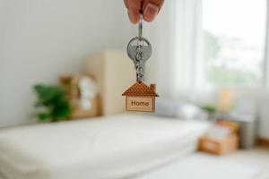 Moving house, relocation. The key was inserted into the door of the new house, inside the room was a cardboard box containing personal belongings and furniture. move in the apartment or condominium photo