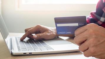 businessman hands using laptop computer for online shopping at home. Hand holding credit card with payment detail page display and credit card, Online shopping and stay home concepts.