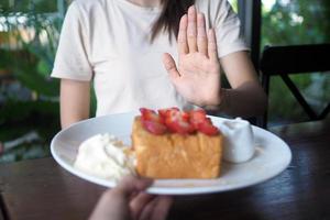 mujer negar a comer dulces para peso pérdida y bueno salud. foto