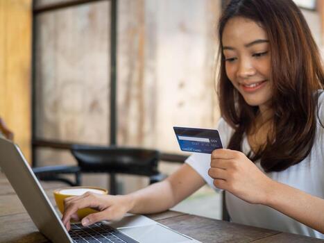 Woman using credit card to shop online. shoping personal belongings through various web application applications in notebook. photo