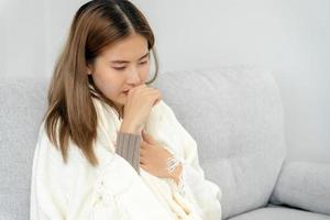 sick woman with a headache sitting under blanket, female sneezing and runny nose with seasonal influenza, allergic, high fever and influenza, resting, virus, coronavirus, feel illness, respiratory photo