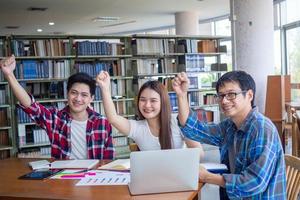 Asian university students read books and study together in the library. photo