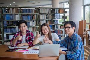 asiático Universidad estudiantes leer libros y estudiar juntos en el biblioteca. foto