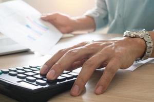 Businessmen sit and press the calculator to calculate and predict the company's power output according to the previous statistics held. photo