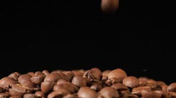 rallentatore di chicchi di caffè tostati che cadono. semi di caffè biologico. video