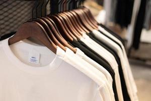 clothes on clothing rack. gray t-shirt  wear on hangers in closet or spring cleaning concept. Summer home wardrobe. Clothing hanging on a clothing rack in a shop or home closet. selective focus. photo