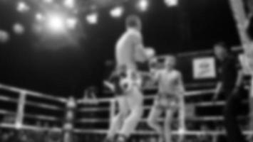 imágenes borrosas estilo fotográfico en blanco y negro de boxeo tailandés o muay thai o kickboxing que boxeador local y extranjero están luchando en el ring en el escenario interior como deporte de arte marcial. kickboxing muay thai foto
