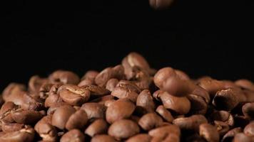 slow motion av rostade kaffebönor som faller. ekologiska kaffefrön. video