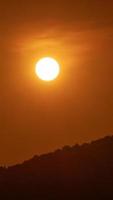 timelapse van dramatische zonsondergang met oranje lucht in een zonnige dag.