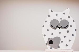 White and gray dot wooden owl figurine isolated. photo