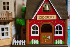 Red school house with bell plastic toy. photo
