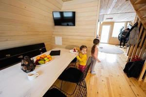 dos hermanas comer fresas en de madera país casa en fin de semana. foto