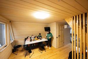 Mother with four children eat fruits in wooden country house on weekend. photo