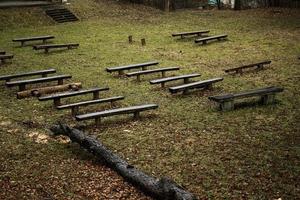 Row of wet wooden benches on alley. photo