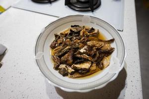 Plate of dried mushrooms soaked in water. photo