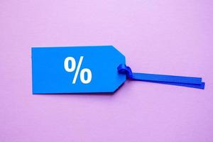 percent symbol on the blue price tag, pink background photo