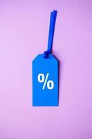 percent symbol on the blue price tag, pink background photo