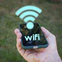 mano participación un inteligente teléfono con Wifi icono, inalámbrico fidelidad foto