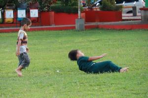 Kudus, December 2022. Photograph of visitors sitting relaxed enjoying the afternoon on the grass of the Kudus city square. photo