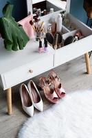 closeup of elegant high heel shoes standing under feminine dressing table photo