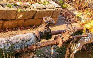 Old rusty faucet for hot water supply and water supply pipes. Thermal insulation broken. photo