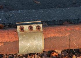 Old rusty pipe for hot water supply. Clamp for removing water leaks. photo