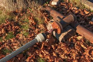 Old rusty faucet for water supply and a plastic pipe. photo