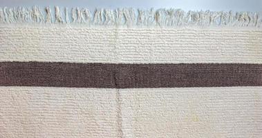 The texture of a light beige with a brown stripe bath towel with a large volume photo