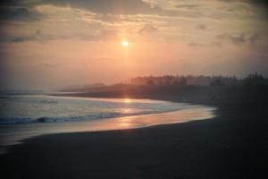 sunset on the beach with an orange sky photo