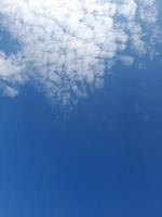 Beautiful white clouds on deep blue sky background. Large bright soft fluffy clouds are cover the entire blue sky. photo