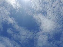 Beautiful white clouds on deep blue sky background. Large bright soft fluffy clouds are cover the entire blue sky. photo