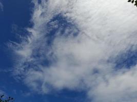 Beautiful white clouds on deep blue sky background. Large bright soft fluffy clouds are cover the entire blue sky. photo