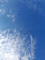 Beautiful white clouds on deep blue sky background. Large bright soft fluffy clouds are cover the entire blue sky. photo