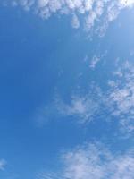 hermosas nubes blancas sobre fondo de cielo azul profundo. grandes nubes esponjosas suaves y brillantes cubren todo el cielo azul. foto