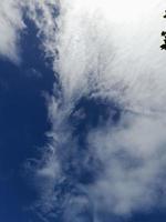 Beautiful white clouds on deep blue sky background. Large bright soft fluffy clouds are cover the entire blue sky. photo