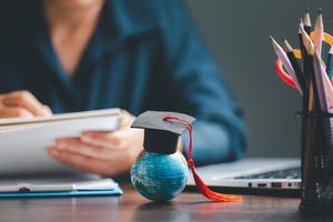 Graduation cap with Earth globe. Concept of global business study, abroad educational, Back to School. Education in Global world, Study abroad business in universities in worldwide. language study photo