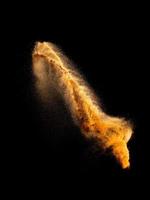 Sand explosion isolated on black background. Freeze motion of sandy dust splash.Sand texture concept. photo