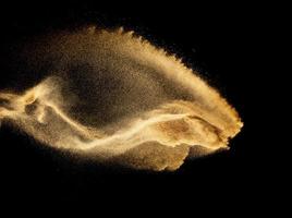 Dry river sand explosion.Brown color sand splash against black background. photo